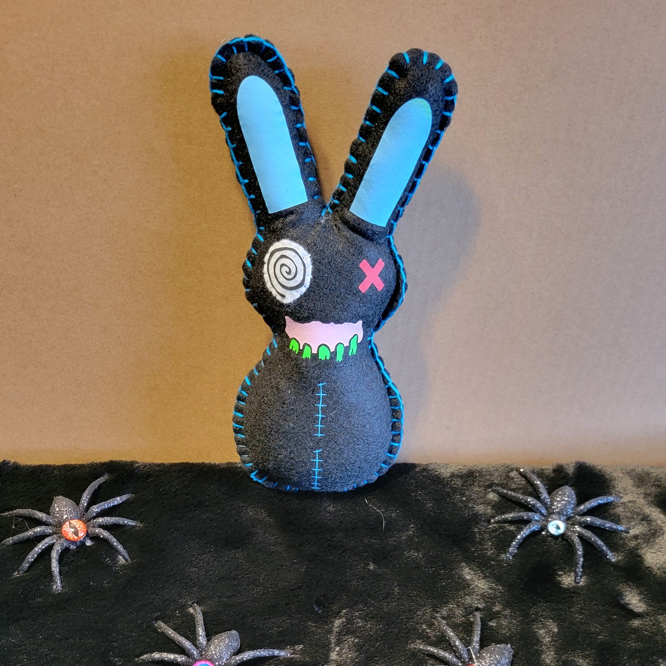 Black Zombie Bunny with Blue Stitches holding a Hatchet behind his bac ...