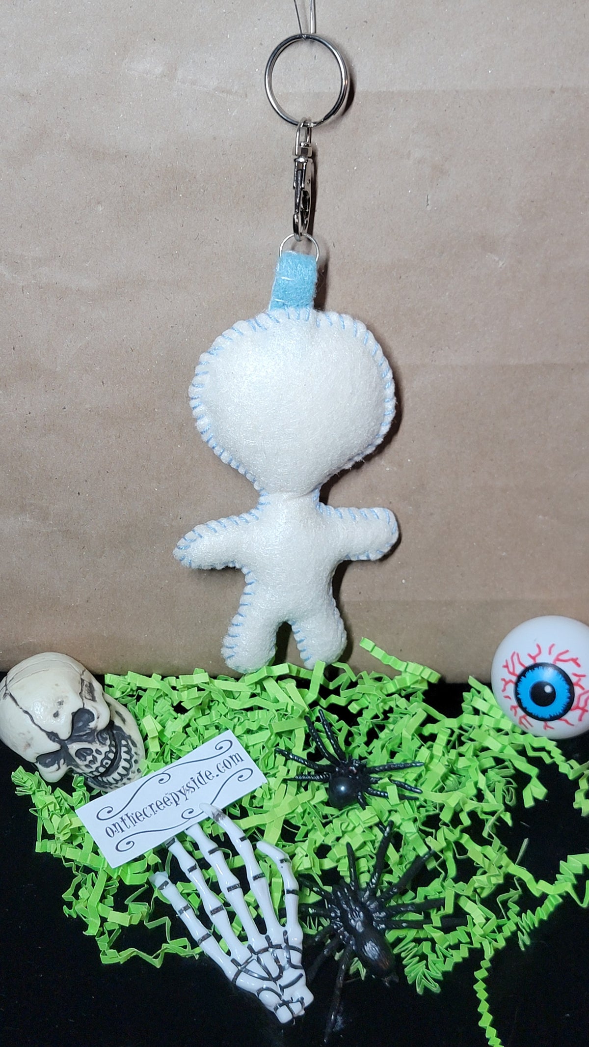 Hand-stitched baby blue Button-Eyed Stitchling bag charm
