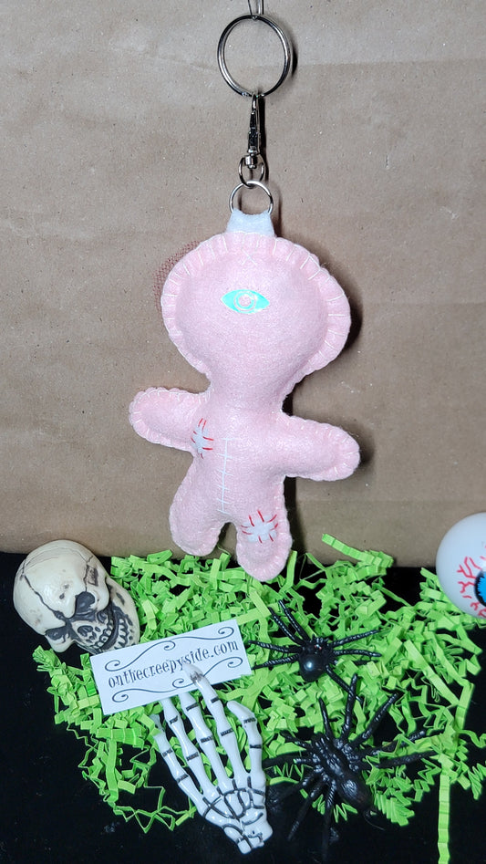 Hand-stitched baby pink Button-Eyed Stitchling bag charm