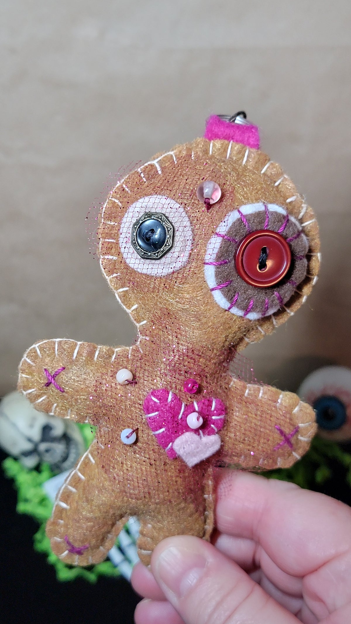 Close view of a one-of-a-kind brown and pink creepy-cute plush charm