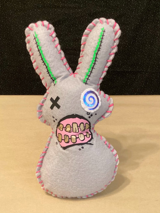 Grey Zombie bunny plush holding a flower behind his back.