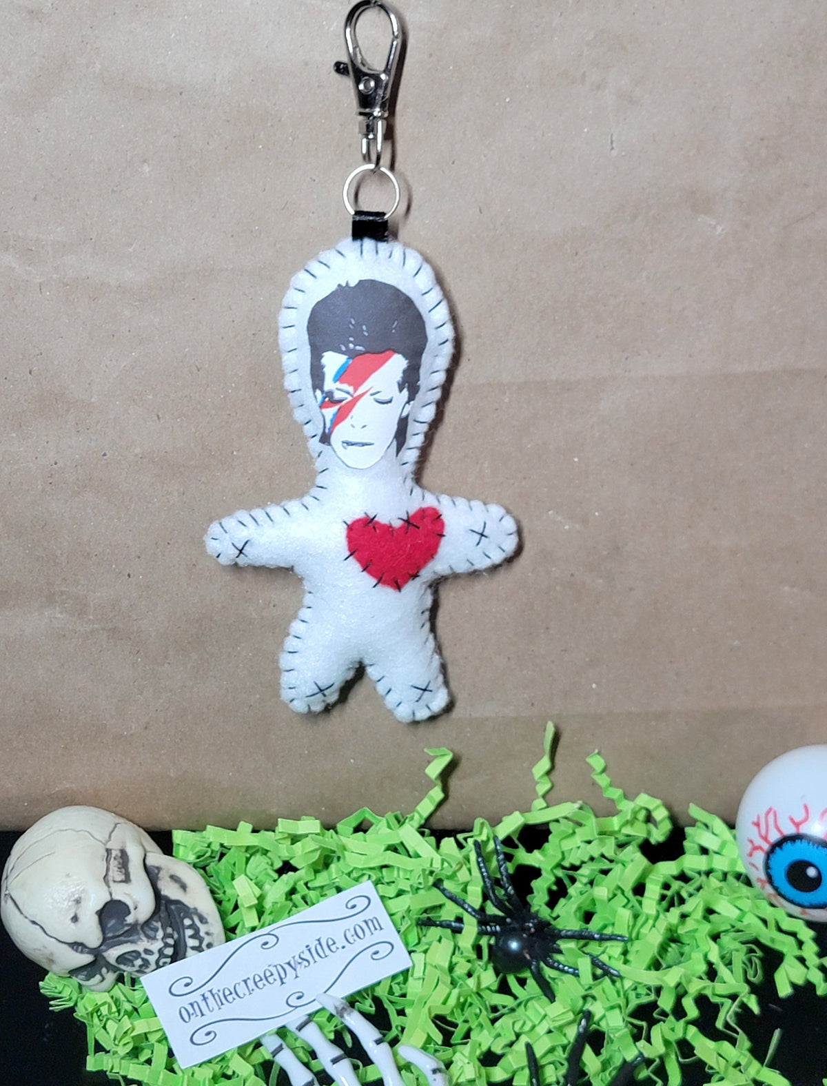 Front view of handmade white felt lightning bolt Rock Star Stitchling keychain with red heart and metal clip