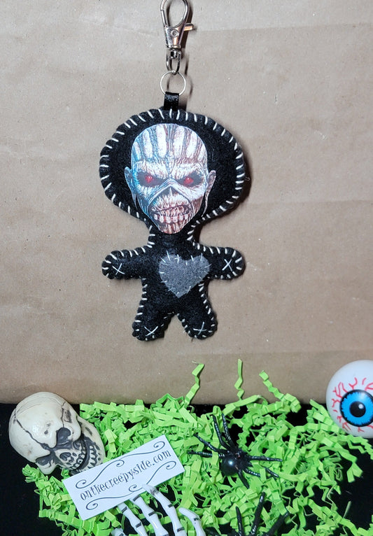 Front view of handmade black felt Eddie Stitchling keychain with silver monster face, red eyes, and gray stitched heart