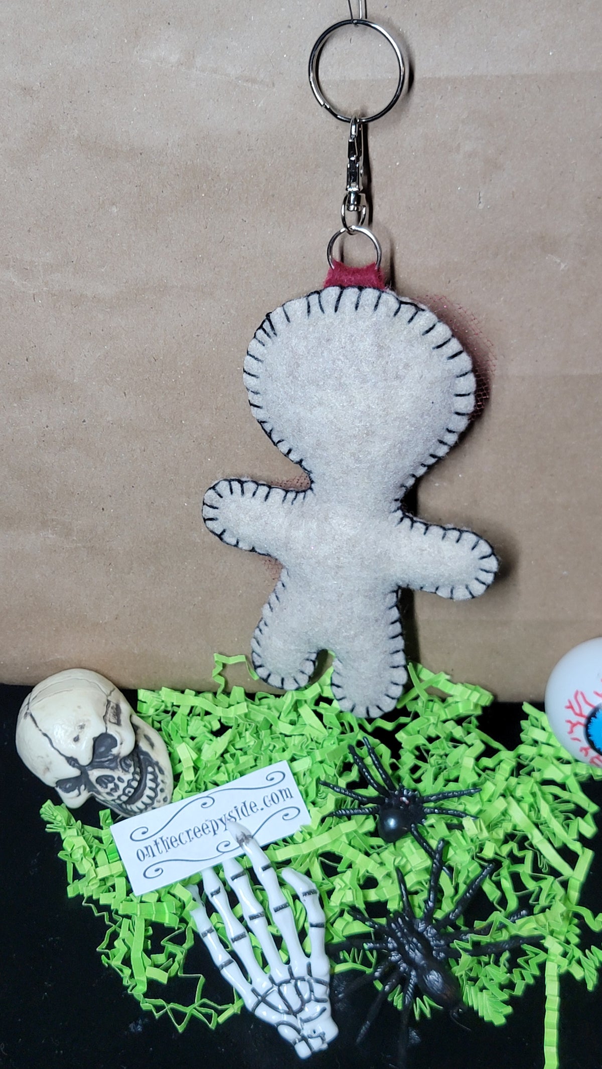 Close view of the hand-stitched details on a Mini Button-Eyed Stitchling bag charm