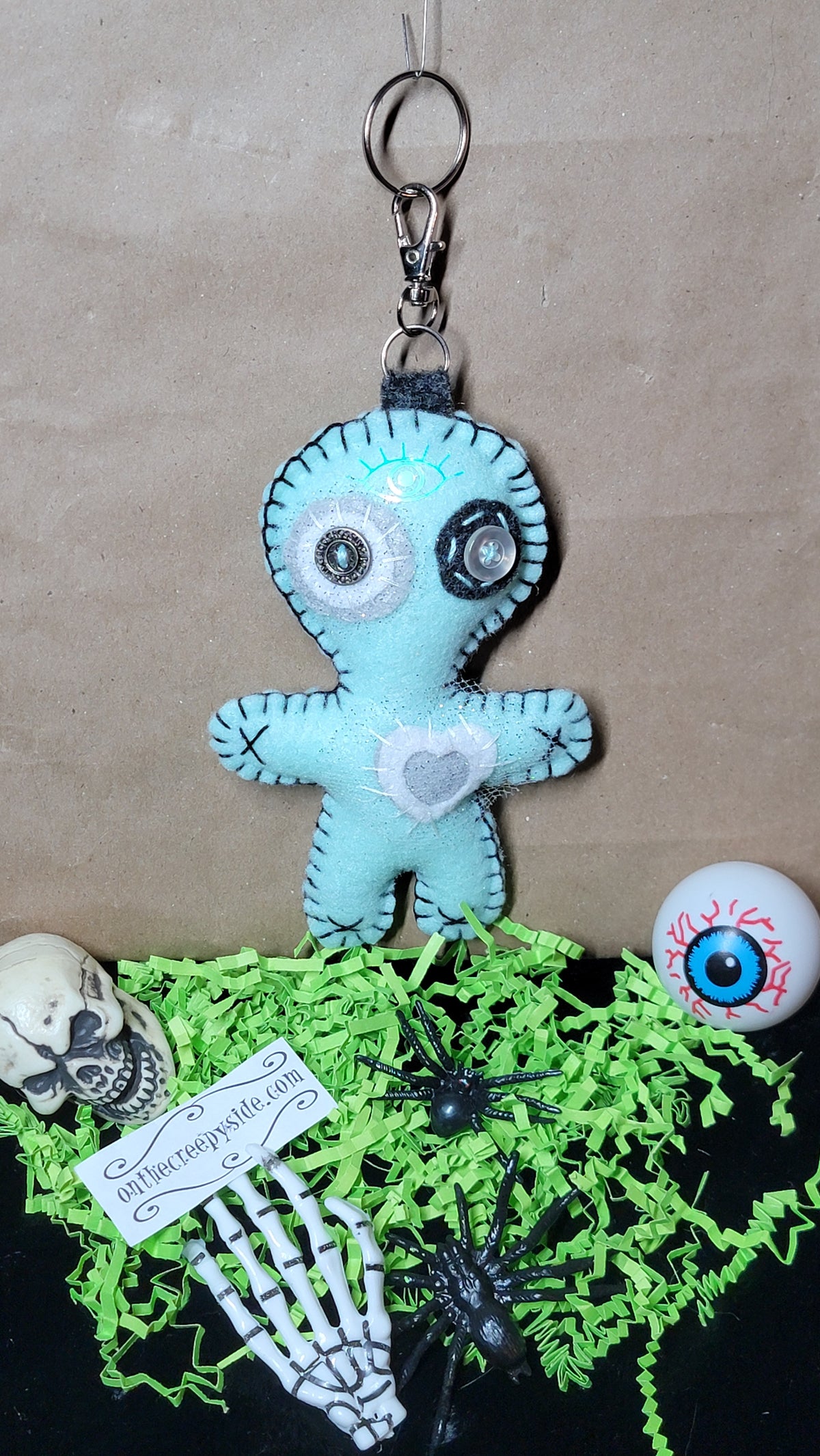 Mint green and grey Button-Eyed Stitchling plush keychain, handmade design