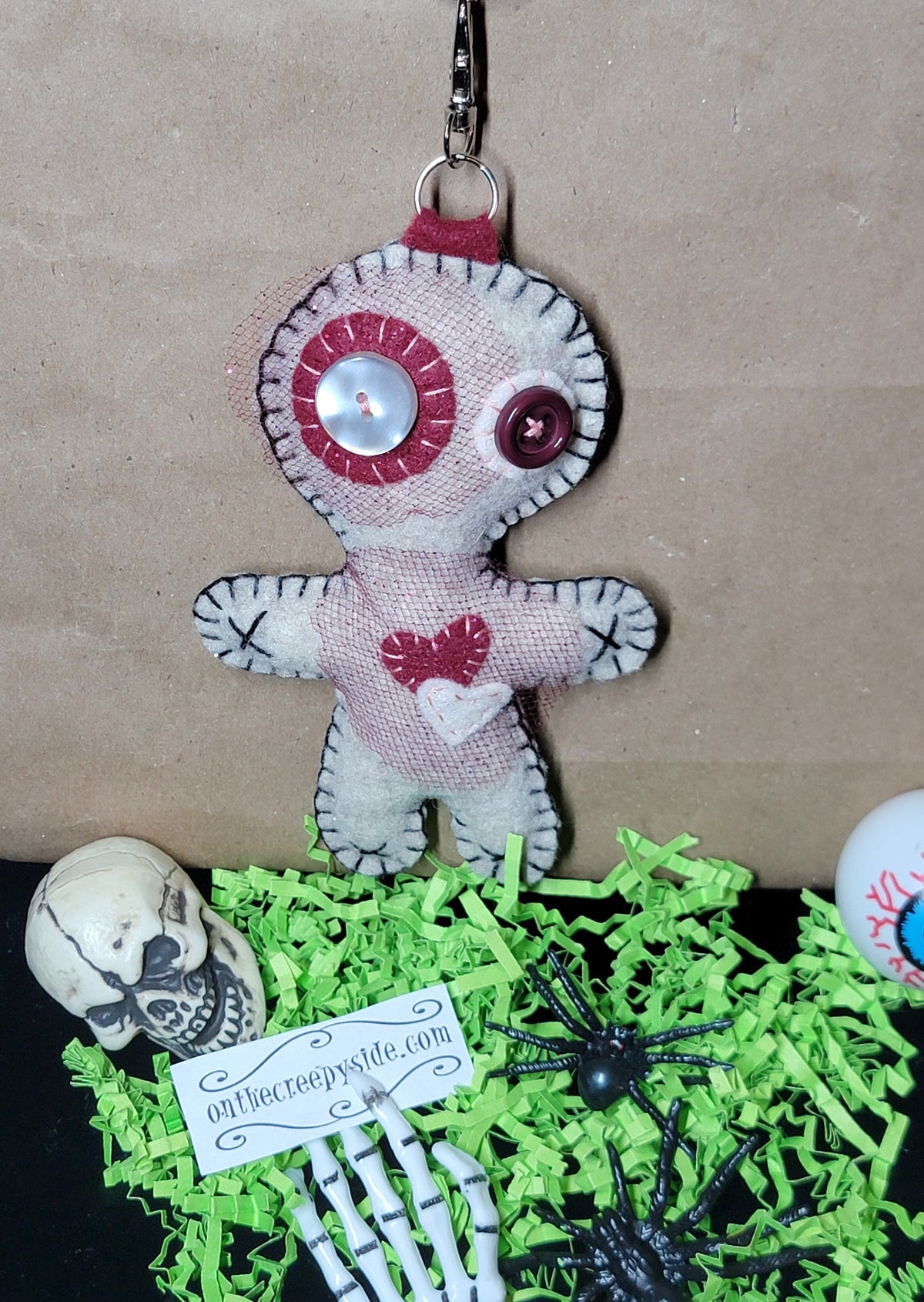Front view of a one-of-a-kind handmade Mini Button-Eyed Stitchling plush keychain