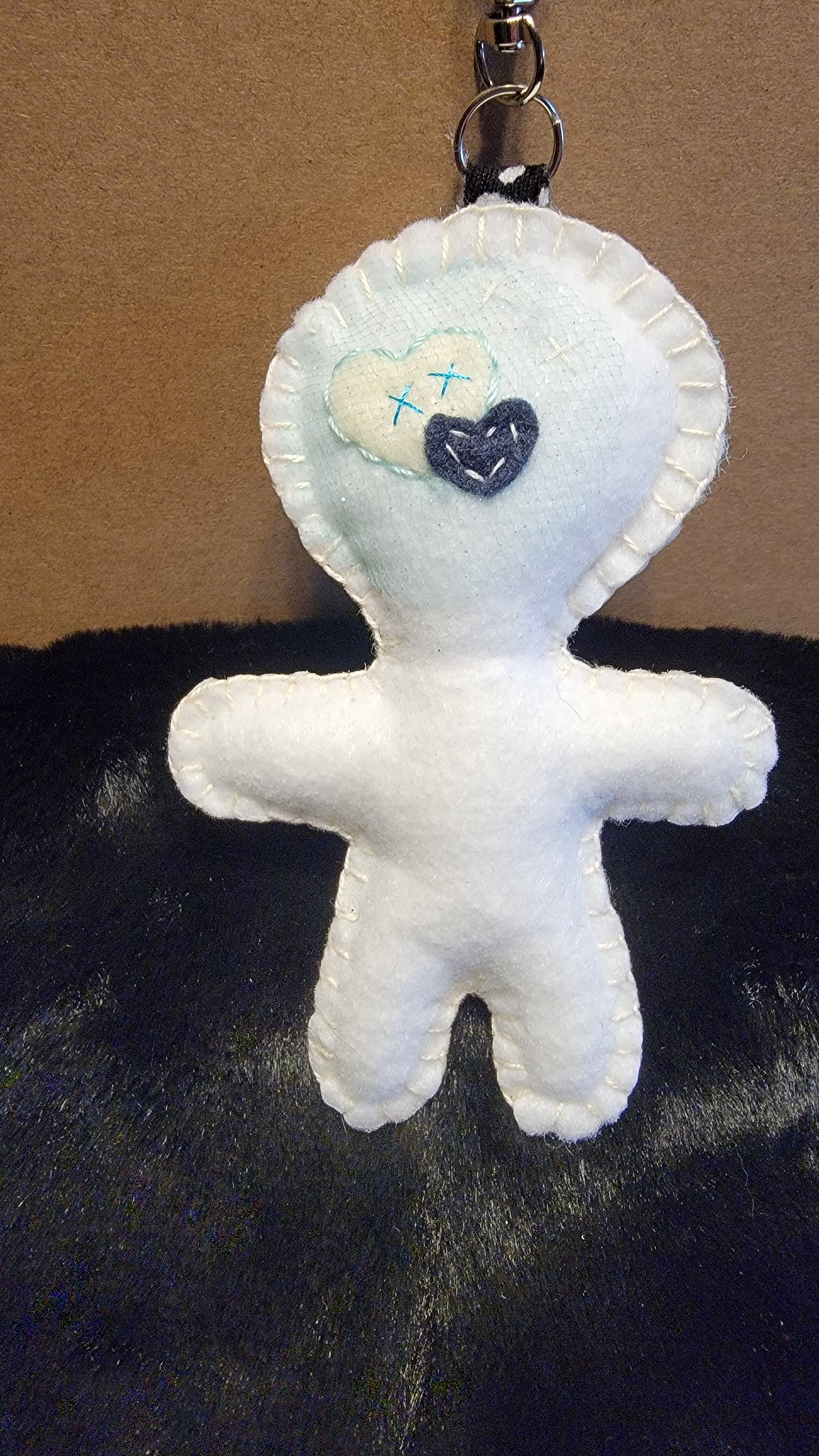 One-of-a-kind white felt Stitchling with button eyes
