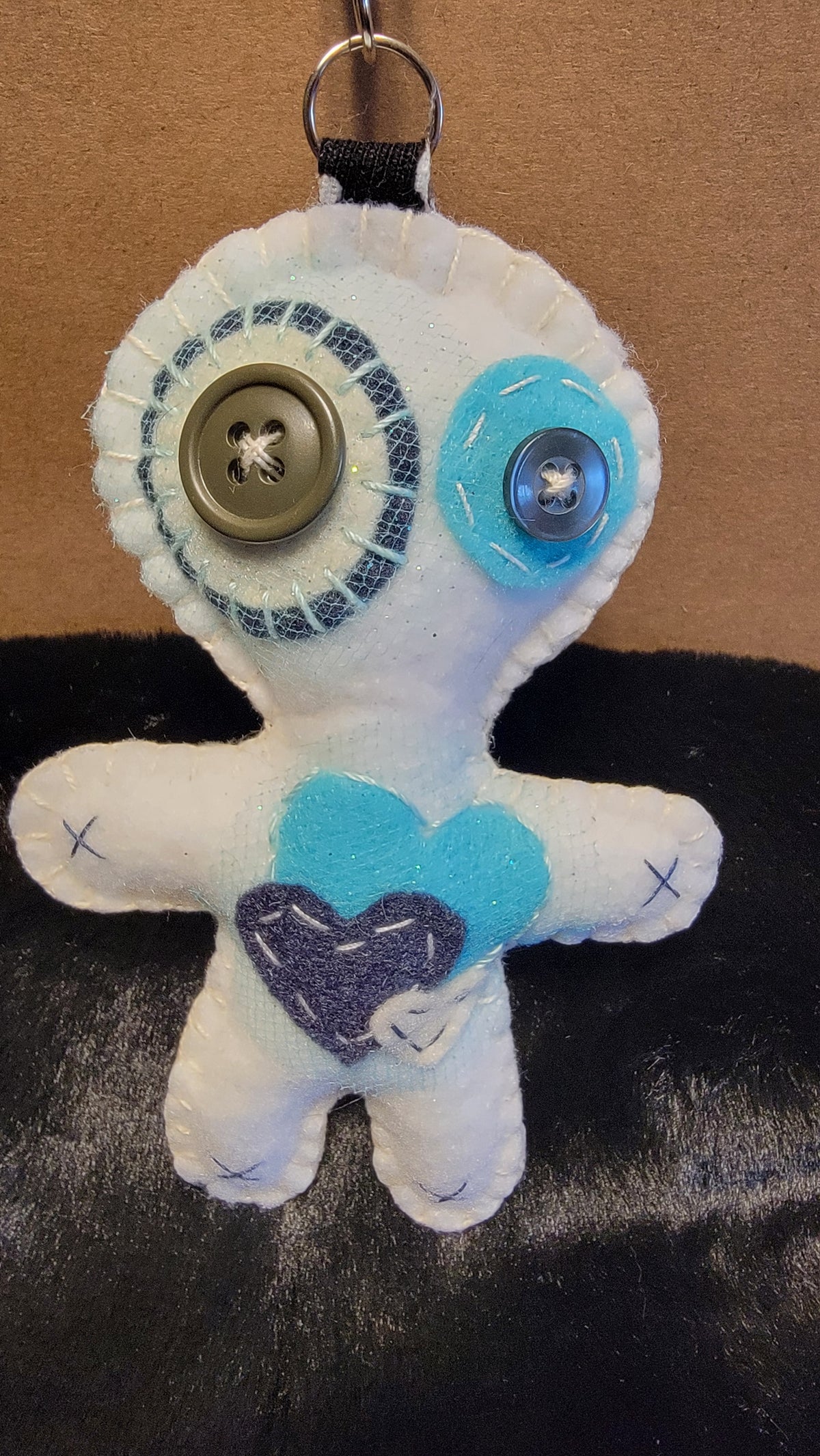 Handmade white Button-Eyed Stitchling plush keychain with creepy-cute details