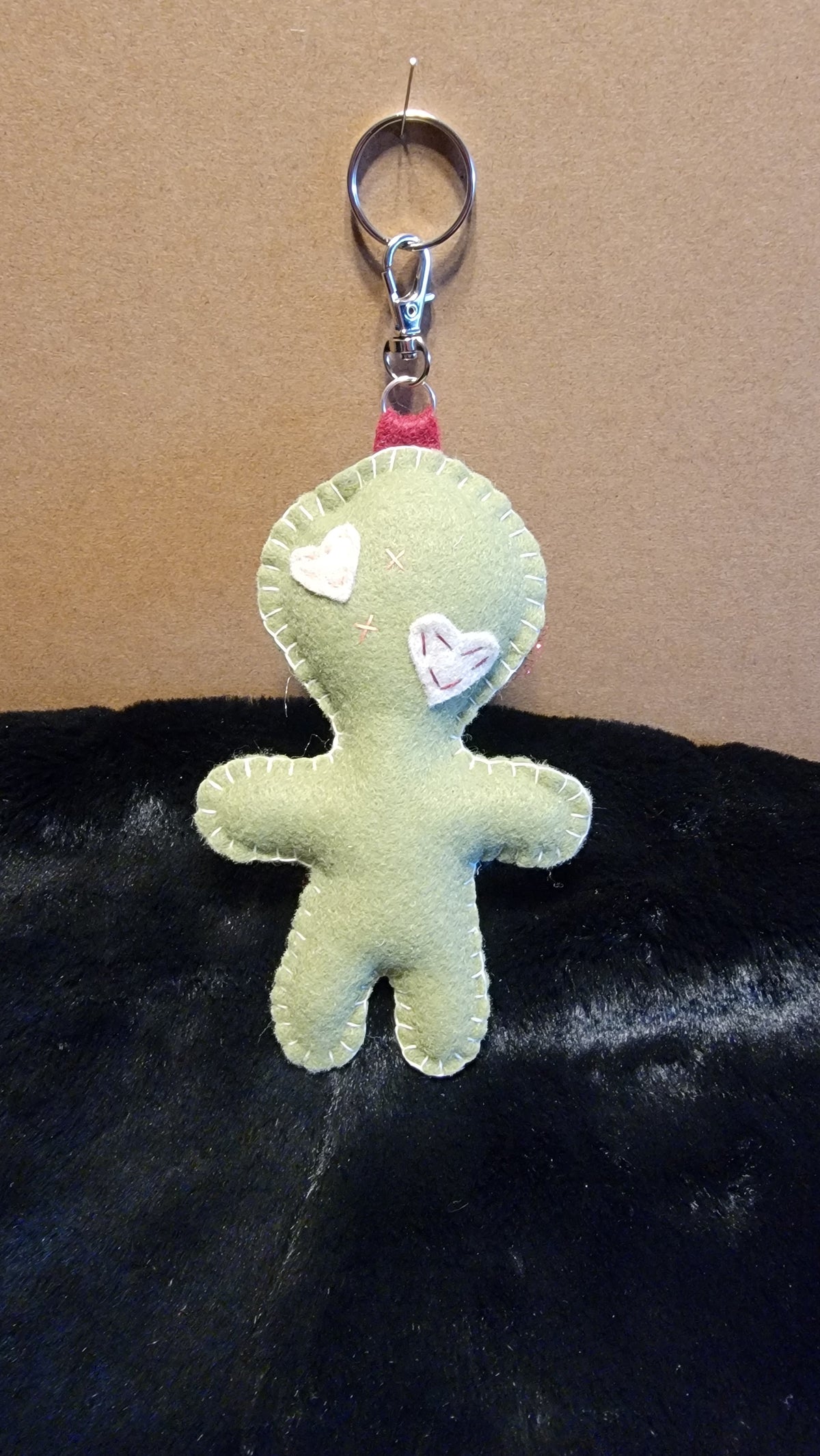 Hand-stitched olive green Button-Eyed Stitchling bag charm