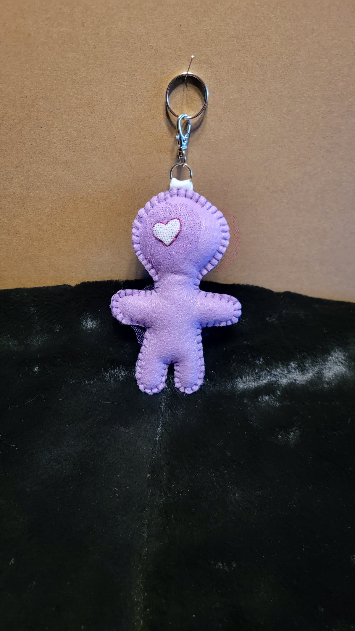 Close-up of purple Button-Eyed Stitchling with hand-stitched felt details